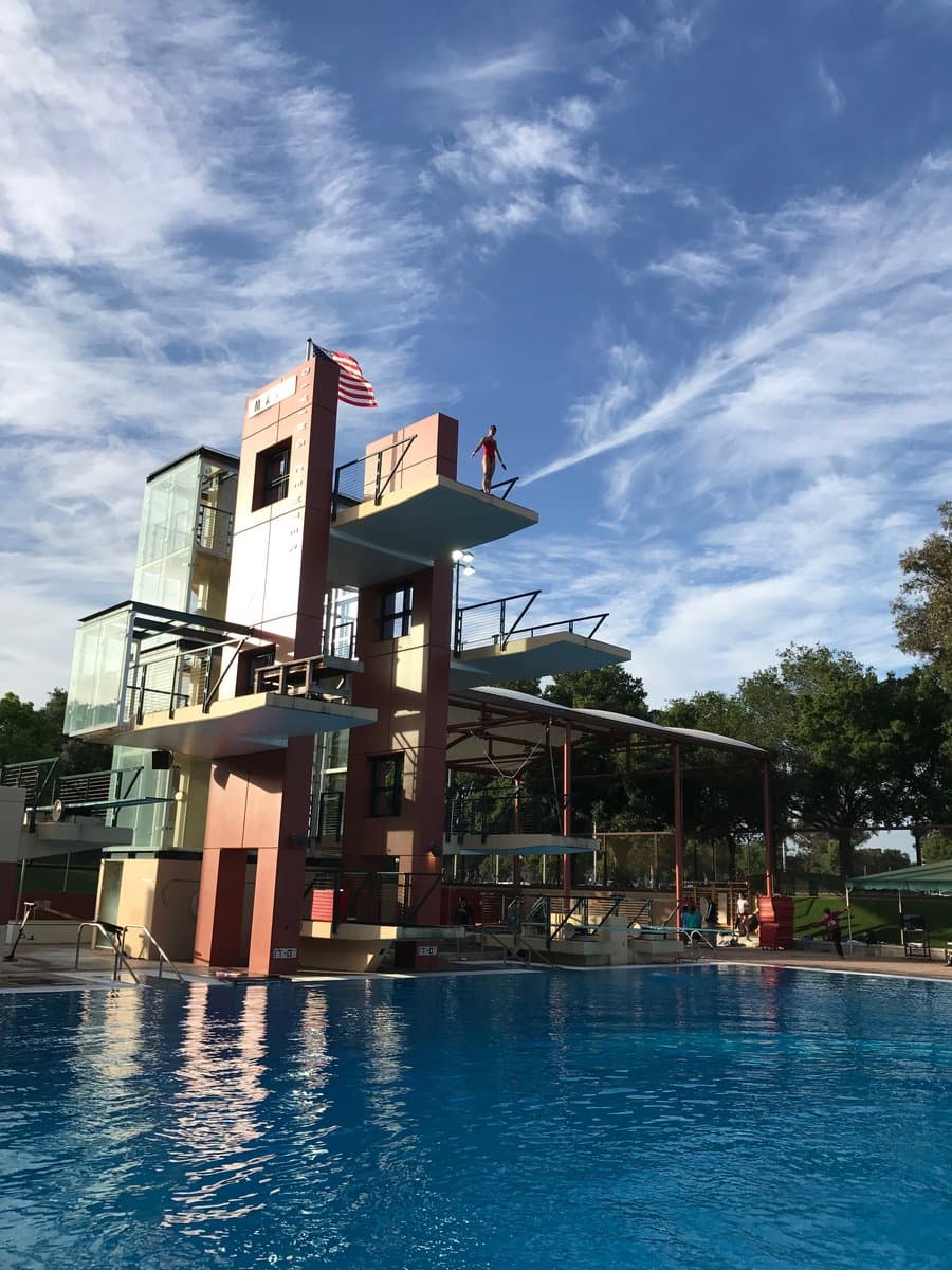 Diver on the platform of the diving tower at the pool